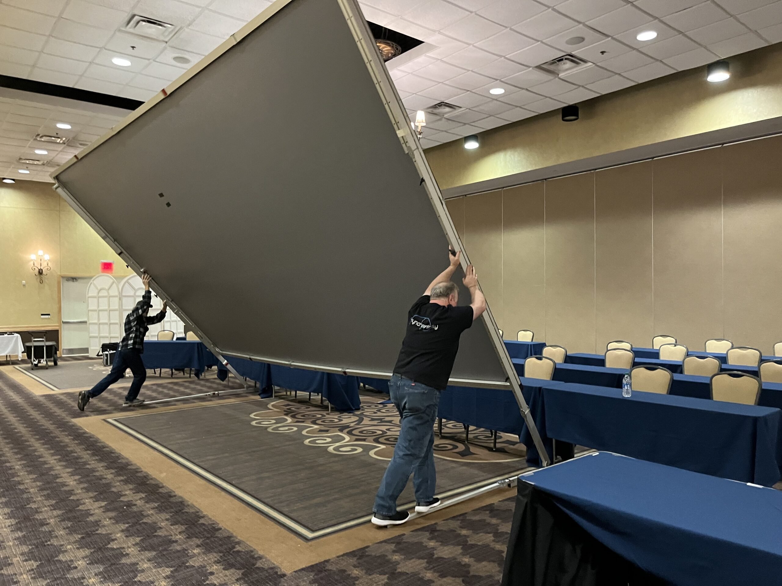 Two Men Lifting a Very Large Panel